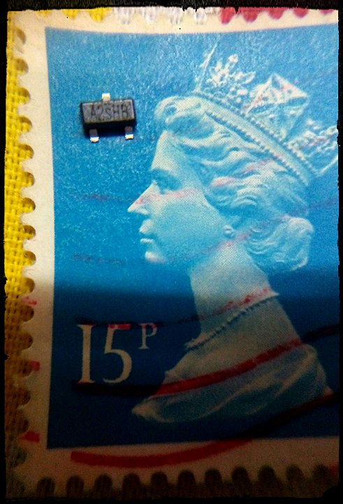 Транзистор поверхностного монтажа, помещенный на британскую почтовую марку для сравнения размеров: https://en.wikipedia.org/wiki/Surface-mount_technology#/media/File:SMDcompared.jpeg